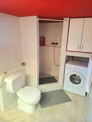 a bathroom with a toilet and a washing machine at Sounio Poseidon Villa in Sounio