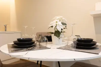 a white table with black dishes and a vase of flowers at Acropolis Local Loft in Athens