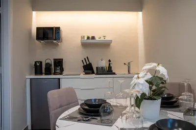 a kitchen with a table with chairs and a microwave at Acropolis Local Loft in Athens