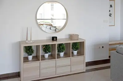 a mirror on top of a wooden cabinet with potted plants at Varkiza Seaside and Views Retreat with Jacuzzi in Vari