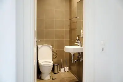 a bathroom with a toilet and a sink at Varkiza Seaside and Views Retreat with Jacuzzi in Vari