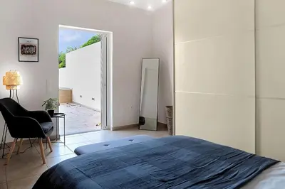 a bedroom with a bed and a chair and a mirror at Varkiza Seaside and Views Retreat with Jacuzzi in Vari