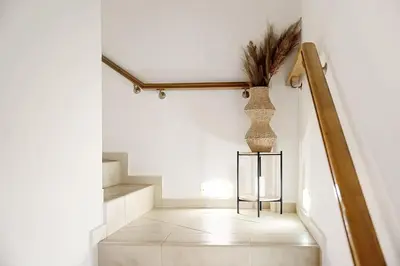 a hallway with a staircase with a vase on the wall at Varkiza Seaside and Views Retreat with Jacuzzi in Vari