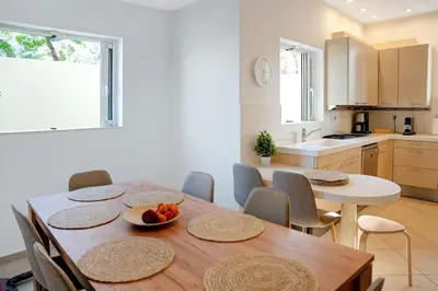 a kitchen and dining room with a wooden table and chairs at Varkiza Seaside and Views Retreat with Jacuzzi in Vari
