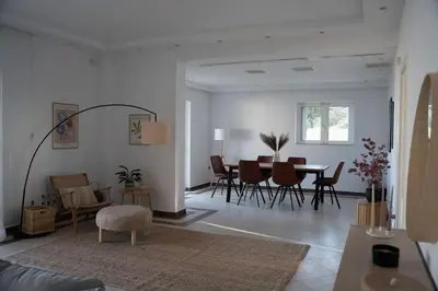 a living room with a table and chairs at Varkiza Seaside and Views Retreat with Jacuzzi in Vari