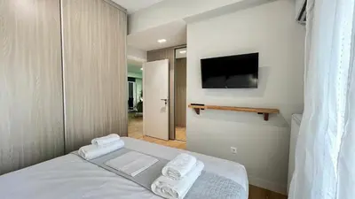 a bedroom with a bed and a flat screen tv at Trion Ierarchon Modern 3 bdr apt in Petralona in Athens