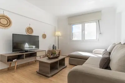 a living room with a couch and a flat screen tv at Spacious Peaceful Family 2BD APT in Athens