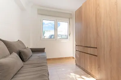 a living room with a couch and a wooden cabinet at Spacious Peaceful Family 2BD APT in Athens