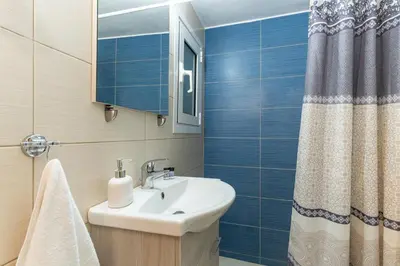a bathroom with a sink and a mirror and a shower at Spacious Peaceful Family 2BD APT in Athens