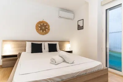 a bedroom with a large white bed with a clock on the wall at Spacious Peaceful Family 2BD APT in Athens
