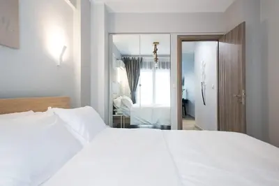 a bedroom with a white bed and a mirror at Unforgettable holidays two steps from Acropolis 3 in Athens