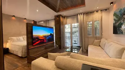 a living room with a tv and a bed at Alfa Luxury Home 3 in Athens