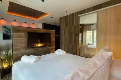 a bedroom with a large white bed and a television at Alfa Luxury Home 3 in Athens