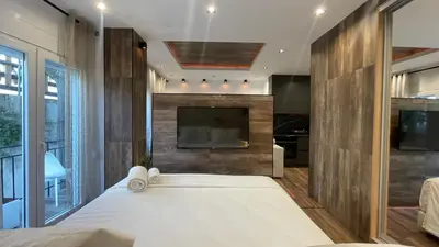 a bedroom with a large bed and a flat screen tv at Alfa Luxury Home 3 in Athens