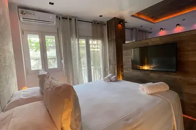a bedroom with a large white bed with a flat screen tv at Alfa Luxury Home 3 in Athens