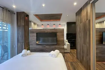 a bedroom with a tv and a bed with towels at Alfa Luxury Home 3 in Athens