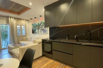 a kitchen with a sink and a living room at Alfa Luxury Home 3 in Athens