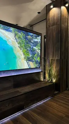 a large flat screen tv on a wall with a view of a beach at Alfa Luxury Home 3 in Athens