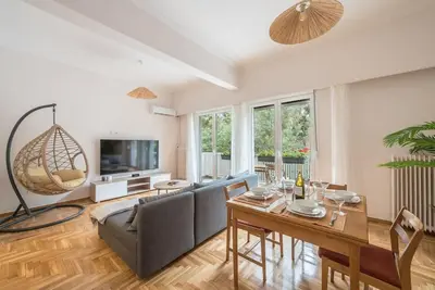 a living room with a table and a couch at Athens Oasis with enchanting green hill views in Athens