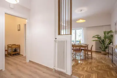 a living room with a table and a dining room at Athens Oasis with enchanting green hill views in Athens