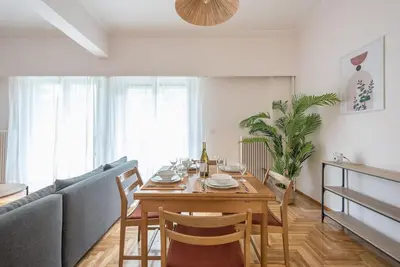 a living room with a table and a couch at Athens Oasis with enchanting green hill views in Athens