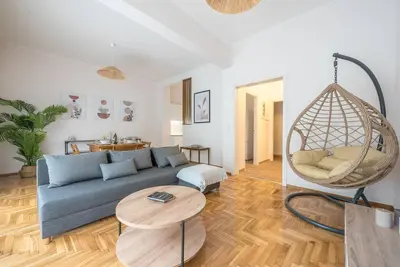 a living room with a blue couch and a swing at Athens Oasis with enchanting green hill views in Athens