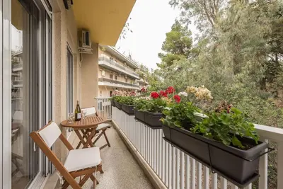 a balcony with severalotted plants and a table and chairs at Athens Oasis with enchanting green hill views in Athens