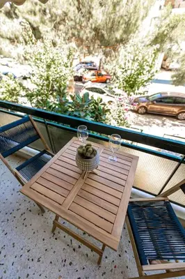 a wooden table with two glasses and a basket of fruit at Flower in Athens
