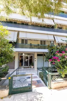 a building with a gate and flowers in front of it at Flower in Athens