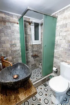 a bathroom with a large stone bath tub next to a toilet at Flower in Athens