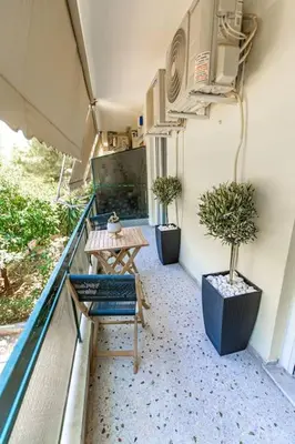a balcony with two potted plants and a table at Flower in Athens