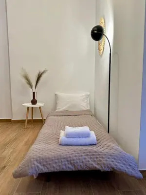 a bed with two towels on it in a room at Urban Retreat , Psirri Athens City Center in Athens