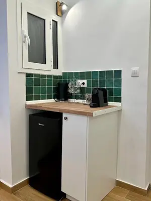 a kitchen with white cabinets and a black dishwasher at Urban Retreat , Psirri Athens City Center in Athens