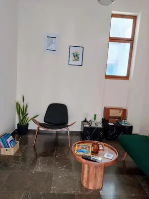 a living room with a chair and a table at Midcentury Modern Apartment in Piraeus