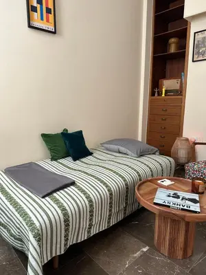 two beds in a room with a table at Midcentury Modern Apartment in Piraeus