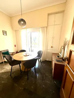a room with a table and chairs and a kitchen at Midcentury Modern Apartment in Piraeus