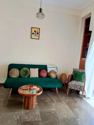 a living room with a green couch and a table at Midcentury Modern Apartment in Piraeus