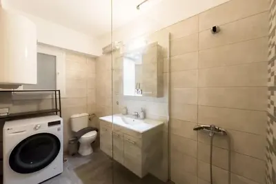 a bathroom with a sink and a toilet and a washing machine at Elegant Athens Downtown Studio in Athens