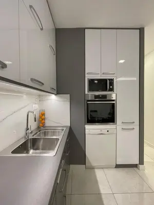 a kitchen with white cabinets and a sink and a microwave at Kate's Nest Athens in Athens