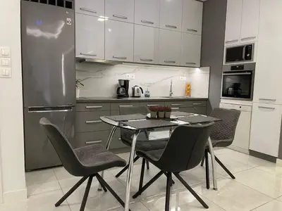 a kitchen with a table and chairs and a refrigerator at Kate's Nest Athens in Athens