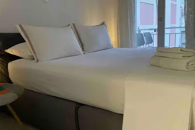 a large white bed with towels on top of it at Alfa house in the center! in Athens