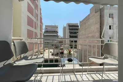 a balcony with chairs and a table on a building at Alfa house in the center! in Athens