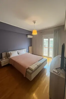 a bedroom with a bed and a television in it at Sunny Escape in Alimos, close to the beach in Athens