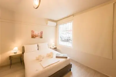 a bedroom with a white bed and a window at Modern Comfort Apt near centre in Athens