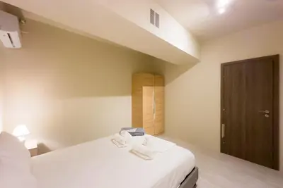 a bedroom with a bed with two towels on it at Modern Comfort Apt near centre in Athens