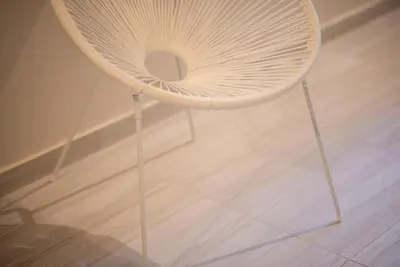 a white chair sitting on top of a wooden floor at Modern Comfort Apt near centre in Athens