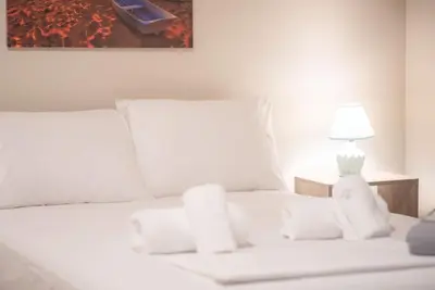 a white bed with pillows and a lamp on it at Modern Comfort Apt near centre in Athens