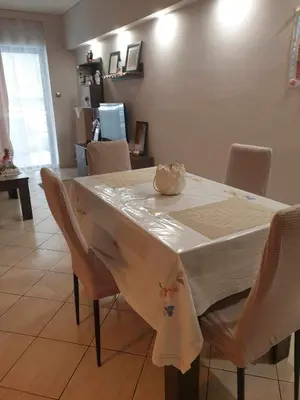 a dining room table with a white table cloth and chairs at Piraeus Seaside Apartment Escape in Piraeus