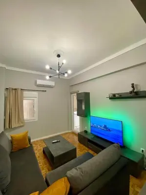 a living room with a couch and a flat screen tv at Sweety Flat Marina Zeas Piraeus in Piraeus