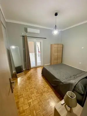 a bedroom with a bed and a wooden floor at Sweety Flat Marina Zeas Piraeus in Piraeus